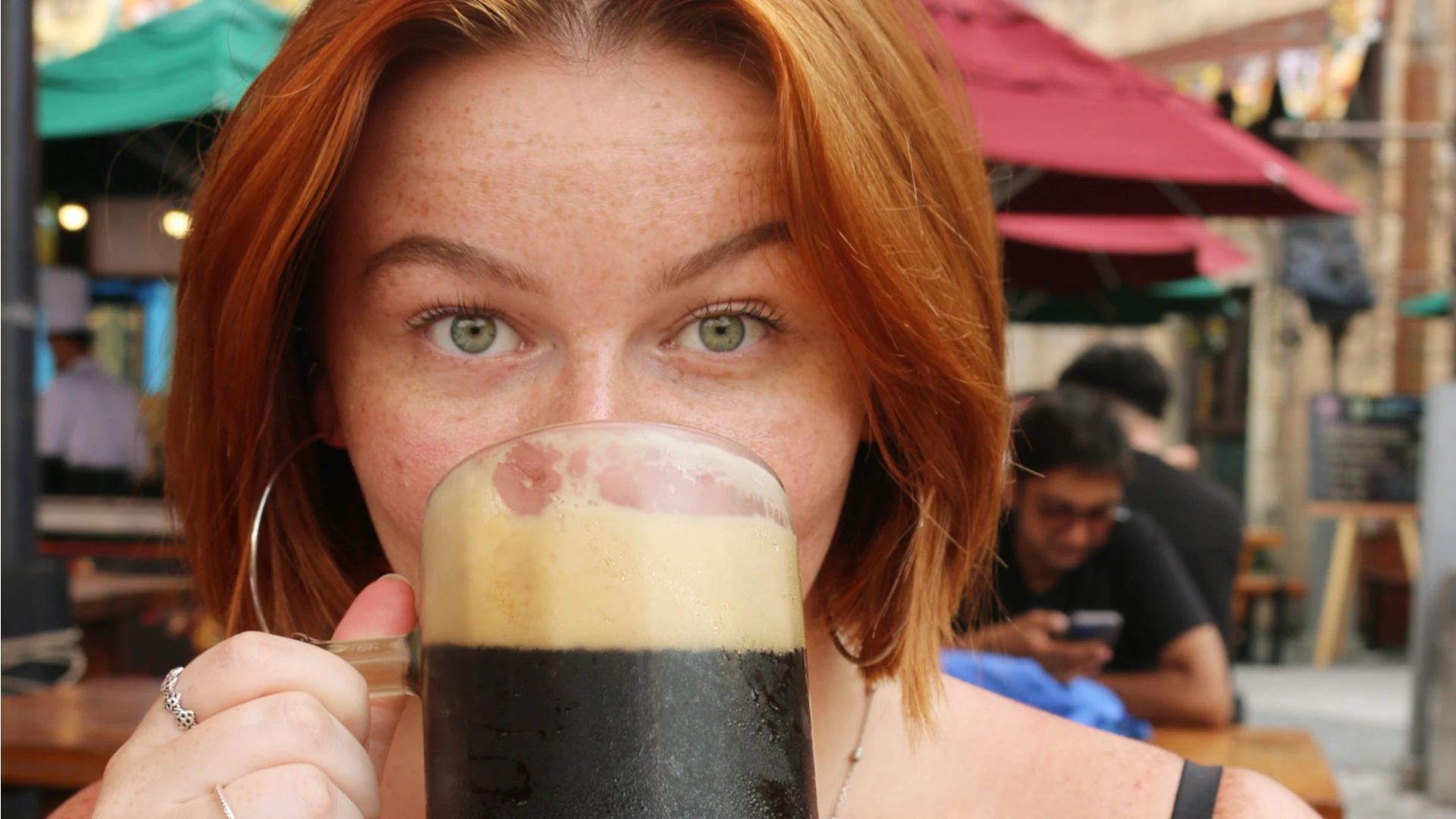 Eloise drinking a dark beer from a stein