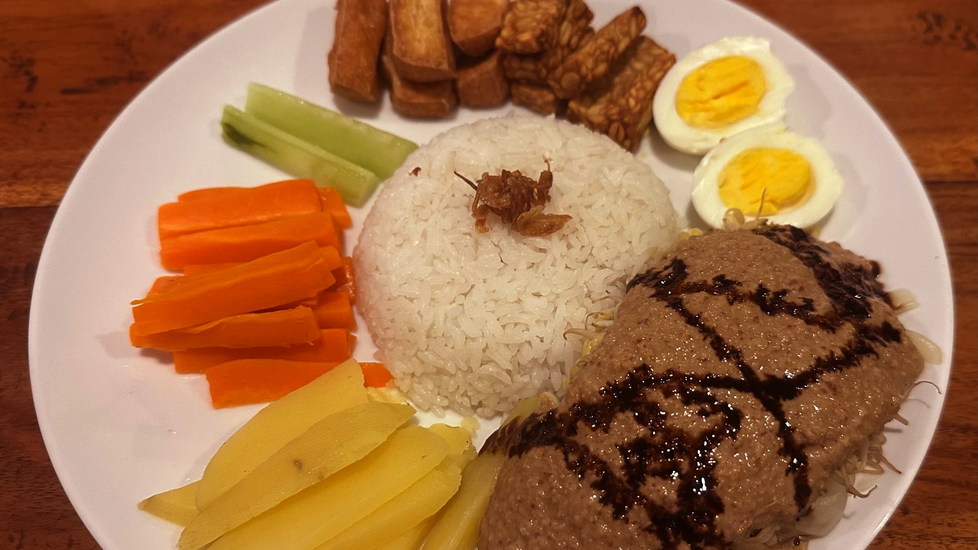 Gado Gado bowl. Egg, curry, rice, carrot, potatoes, cucumber, tofu, tempeh