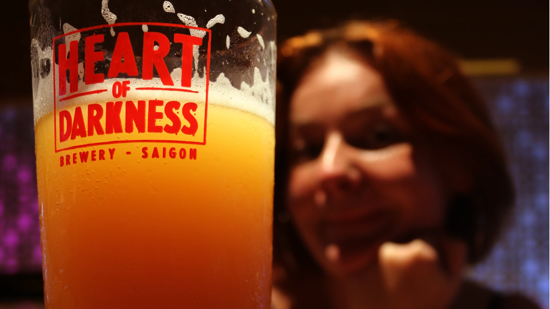 Foreground of a heart of darkness ale with Eloise in the background
