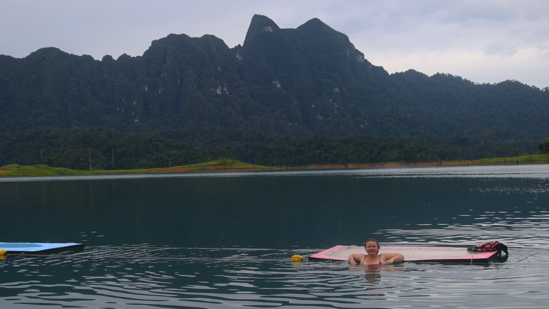 Eloise in the lake resting against the floating dive pads