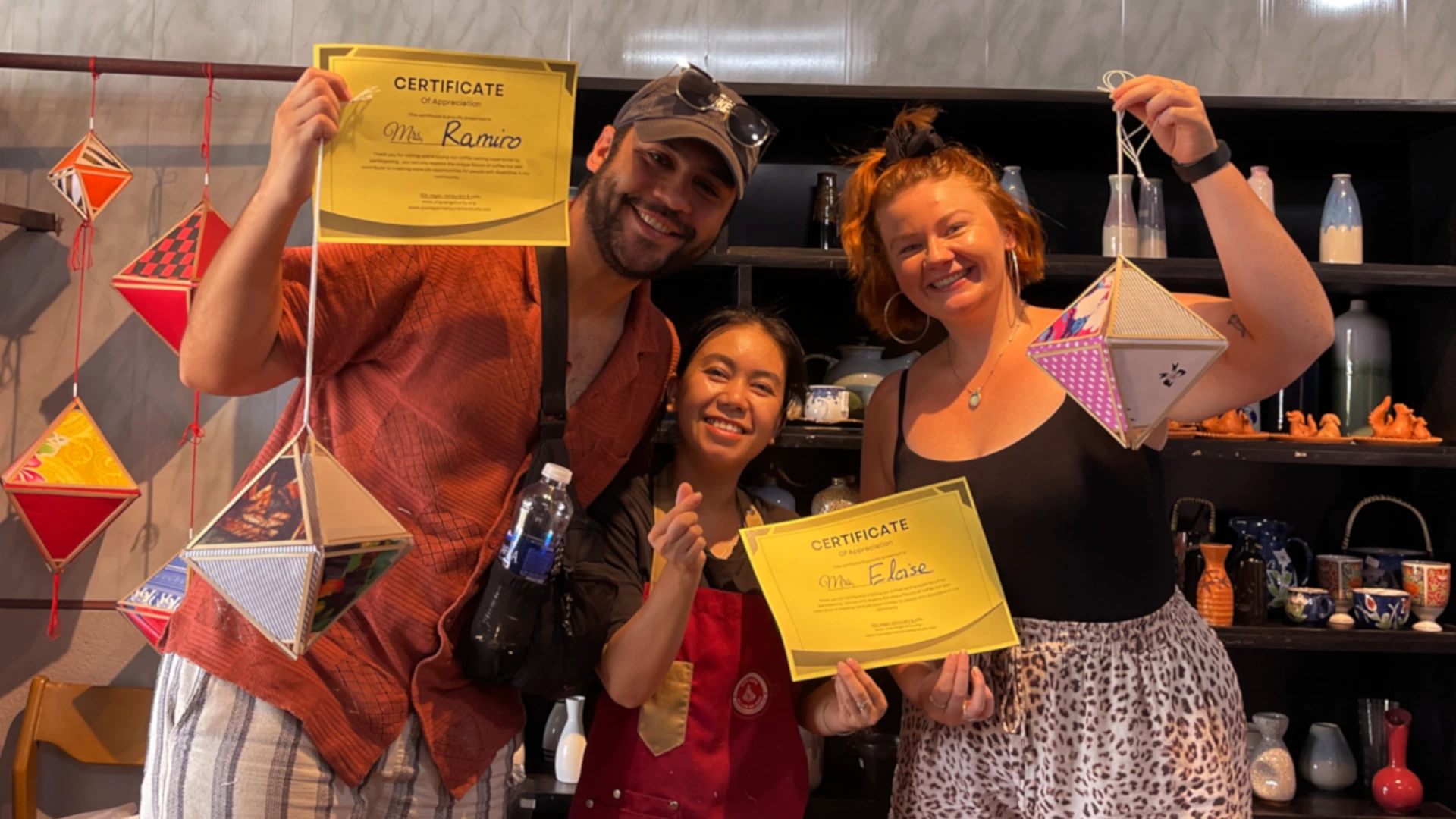 Eloise and Ramiro holding the lanterns they made with the Vietnamese staff member in the middle