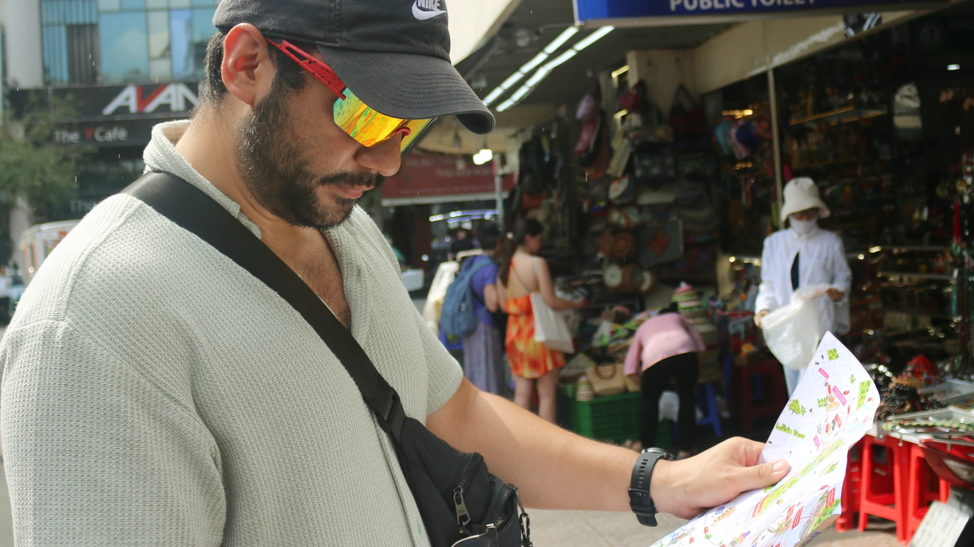Rami reading a map outside a market